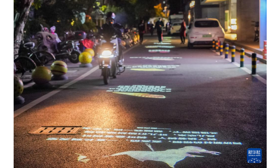 11月23日拍摄的“诗歌单行道”。在上海市杨浦区四平路1028弄，由于不属于市政干道，这里有一条没有路名也没有路灯的道路。今年10月，作为2021上海城市空间艺术季项目之一的“诗歌单行道”在四平路1028弄点亮，长短不一的诗歌通过灯光投影在地面，点亮了居民的回家路。据了解，单行道投影灯每天下午5时亮灯，熄灯时间定在凌晨1时，诗歌内容定期更换，都是由本地居民创作。新华社记者 王翔 摄