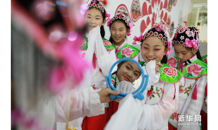 3月27日，邢台市内丘县大良村小学学生对着镜子练习表情。新华社发（刘继东摄）