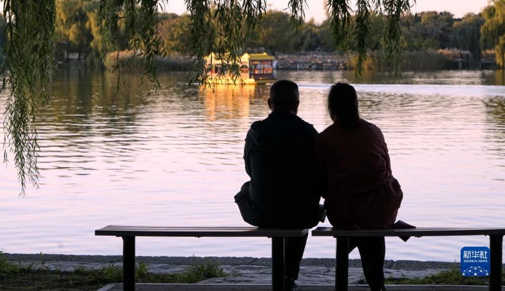 10月11日，游人在圆明园湖畔观赏秋色。当日，北京秋高气爽，圆明园遗址公园水波潋滟，景色宜人。新华社记者 李欣 摄