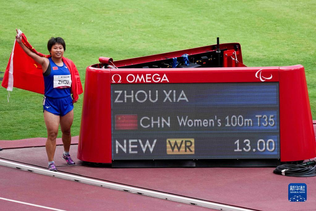 8月27日，在东京残奥会田径女子100米T35级决赛后，中国选手周霞与计时器合影庆祝。新华社记者 朱炜 摄