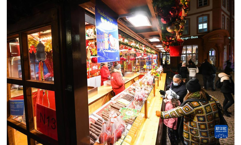 11月22日，人们在德国法兰克福圣诞市场的一家甜点摊铺前驻足。

　　受新冠疫情影响，德国柏林、法兰克福等地的圣诞市场有的取消，有的在较为严格的防疫措施下开放。

　　新华社记者 逯阳 摄