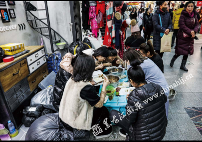 装衣服的箱子当做餐桌，麻辣烫、酸辣粉、拉面……简简单单就是一顿午餐。一顿或许还算可口，可是每天她们都会吃这样的简餐，不在意是否有利于健康。即使午餐时间，也会有顾客来问款问价，批发市场客流量大，忙碌是必然的。