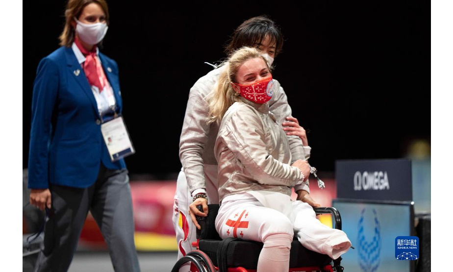 8月25日，在东京残奥会轮椅击剑女子佩剑个人赛A级决赛后，中国选手边静（中）推着格鲁吉亚选手妮诺（右）离开比赛场地。新华社记者 熊琦 摄
