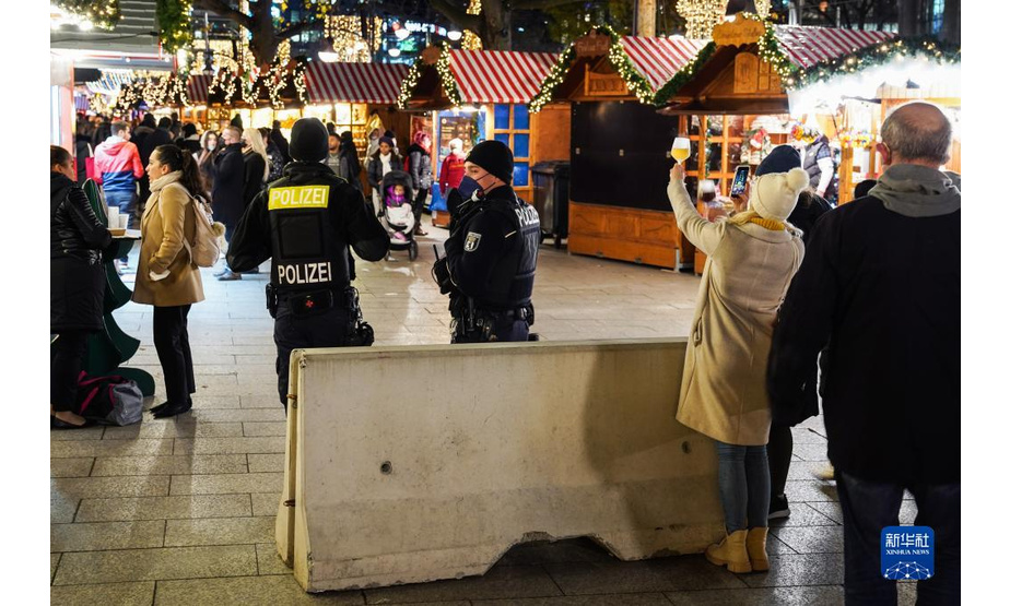 11月22日，在德国首都柏林的布赖特沙伊德广场，两名警察在圣诞市场执勤。

　　受新冠疫情影响，德国柏林、法兰克福等地的圣诞市场有的取消，有的在较为严格的防疫措施下开放。

　　新华社发（斯特凡·蔡茨摄）