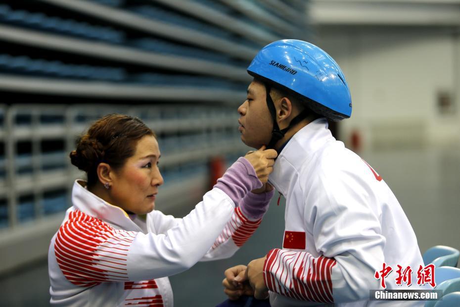 1月18日，黑龙江七台河，张杰（左）帮“特奥宝贝”调整头盔。张杰是一名短道速滑世界冠军，也是七台河市特殊教育学校特奥短道速滑队发起人兼公益教练员。她培养的残障孩子里，有的成为了特奥会世界冠军，有的当上了速滑助教。由于张杰无微不至的关心和教导，孩子们亲切地称她为“教练妈妈”。 中新社记者 姜辉 摄