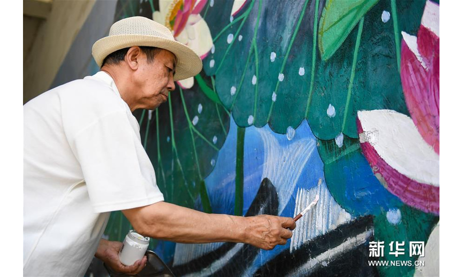 7月18日，吴吉人在吉林市船营区光华路附近一个小区的墙壁上作画。新华社发（颜麟蕴摄）
