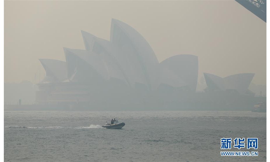 11月21日，在澳大利亚悉尼，一艘快艇驶过浓烟笼罩下的悉尼歌剧院。 澳大利亚东部近期林火肆虐，悉尼所在的新南威尔士州自进入今年林火季以来，过火面积超过100万公顷。林火造成悉尼浓烟围城，市民生活受到影响。 新华社记者 白雪飞 摄