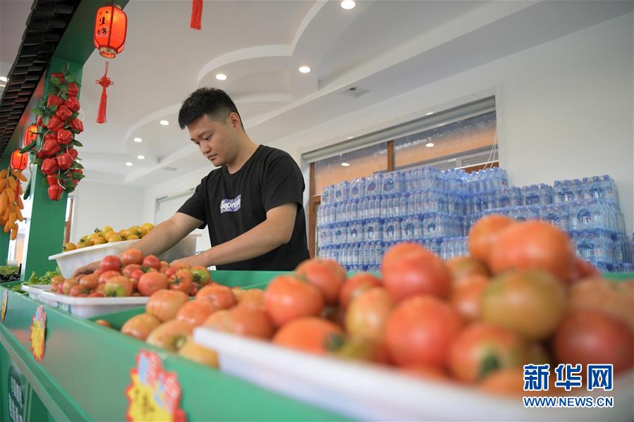 7月5日，在黑龙江省肇东市昌五镇昌盛村农业生态观光园农产品展销区，工作人员在整理果蔬。黑龙江省肇东市昌五镇昌盛村农业生态观光园占地千余亩，融合了种植采摘、民俗产品展销、旅游观光等项目，方便周边农民就近就业，助力脱贫增收。新华社记者 王建威 摄