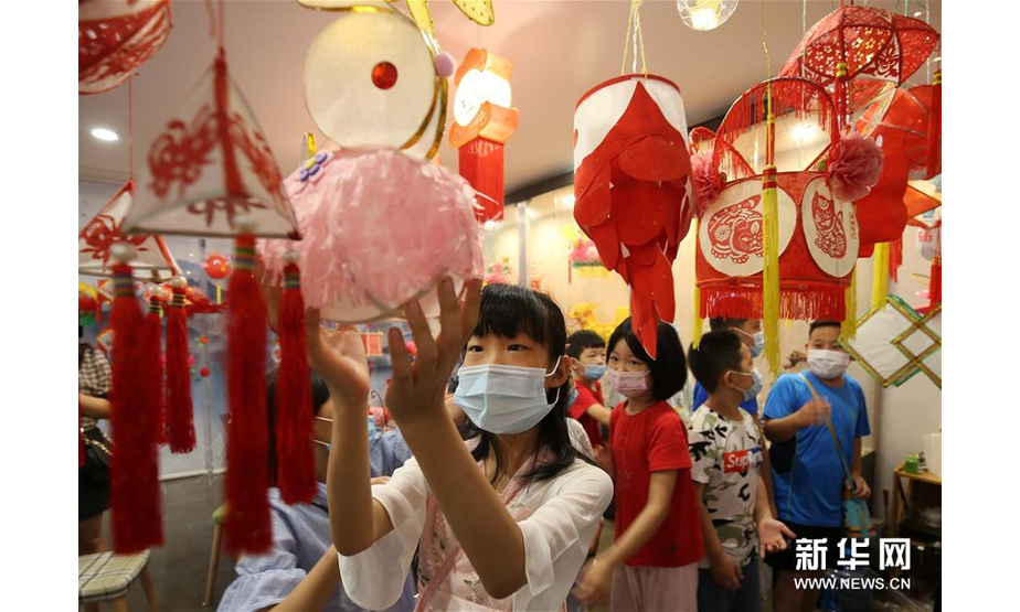 7月8日，山东省潍坊市潍城区城关街道十笏园社区的小朋友被各式各样的传统花灯吸引。新华社发（张驰 摄）