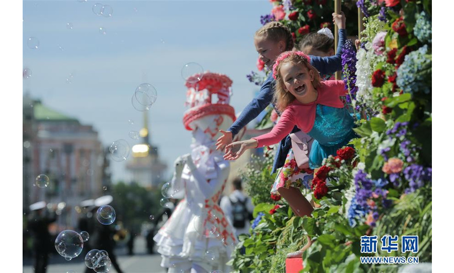 6月12日，人们在俄罗斯圣彼得堡街头参加鲜花大游行，庆祝“俄罗斯日”。 新华社发（莫京娜 摄）