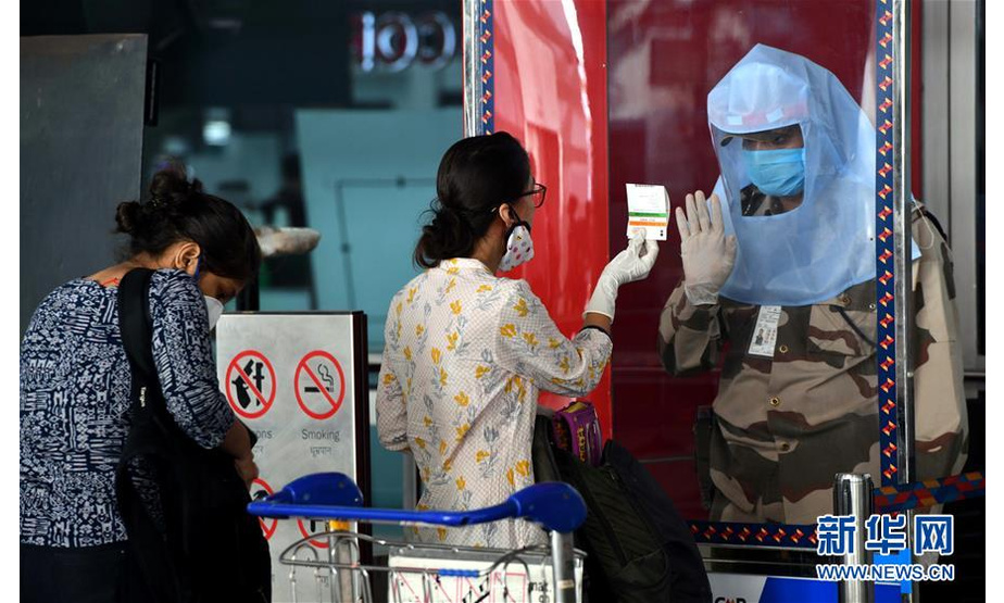 5月25日，在印度新德里英迪拉·甘地国际机场，安保人员核对旅客身份信息。 印度政府允许国内航线自5月25日起恢复。 新华社发（帕塔·萨卡尔摄）