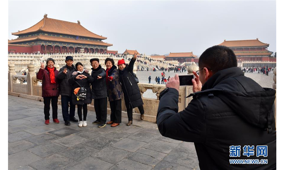 春节期间，在北京工作的吴豪伟夫妇将双方父母接到北京共度佳节。这是在北京故宫，吴豪伟（右一）为家人拍照（2月5日摄）。