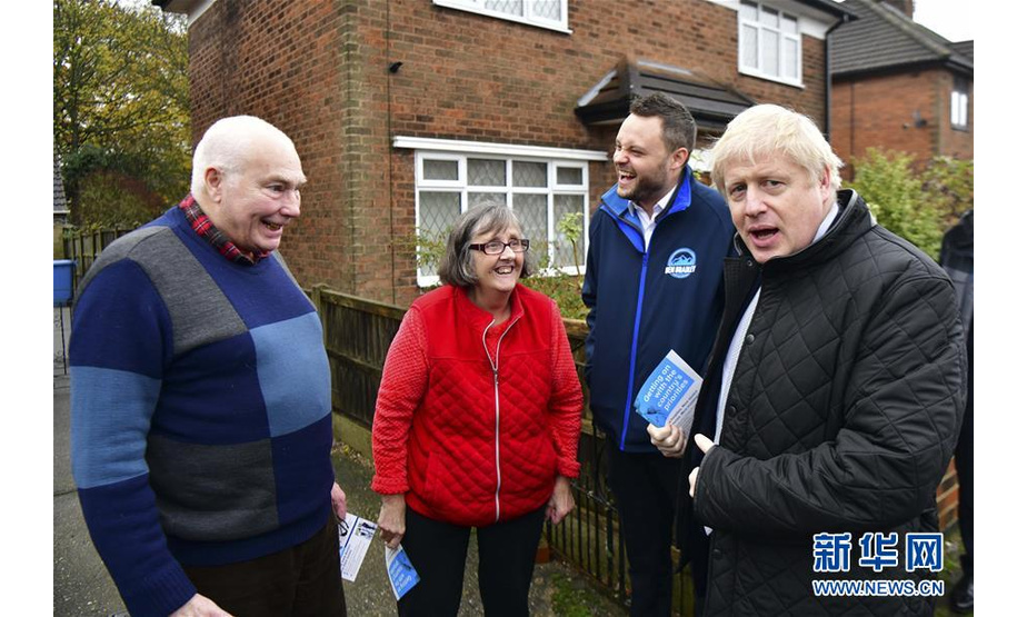 11月16日，在英国曼斯菲尔德，英国首相、保守党领袖鲍里斯·约翰逊（右一）和曼斯菲尔德选区保守党议员候选人本·布拉德利（右二）为大选拉票。新华社发