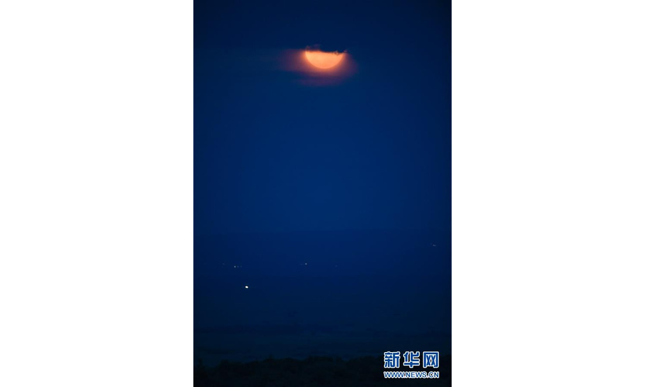 这是6月17日在肯尼亚马赛马拉国家保护区拍摄的被云层遮住的月亮。 新华社记者 李琰 摄