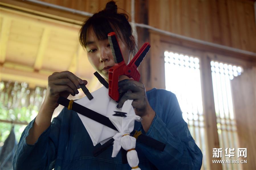 6月30日，陈燃在染坊内绑扎布料。新华社记者 韩晓雨 摄