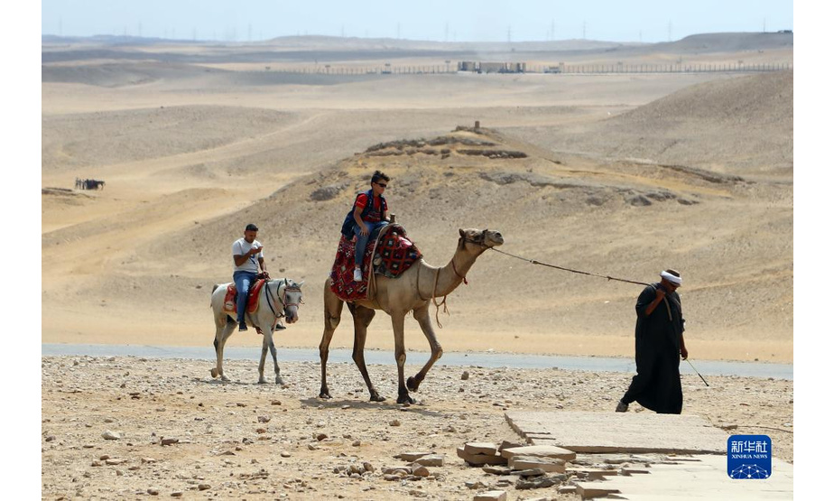9月27日，游客在埃及吉萨金字塔群景区内骑行骆驼和马。

　　每年的9月27日是世界旅游日。新冠疫情导致埃及旅游业受到冲击，游客数量下降明显。但随着埃及国内新冠疫苗的持续接种，各类防疫措施的执行以及旅游资源的宣介和推广，埃及游客数量近来逐渐增多。吉萨金字塔群游客数量现已恢复至疫情前游客数量的一半以上。

　　新华社发（艾哈迈德·戈马摄）