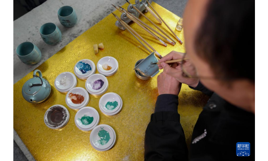 11月21日，在宝丰县一汝瓷工作室，汝瓷艺人在汝瓷茶具上绘画。新华社发（何五昌 摄）