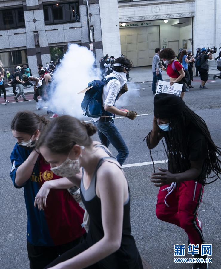 5月31日，在美国首都华盛顿，抗议者躲避警察发射的震爆弹。 由美国明尼苏达州白人警察执法致非洲裔男子死亡事件引发的抗议和骚乱5月31日仍在美国多地持续。31日，美国首都华盛顿民众走上街头抗议警察暴力执法和种族主义。 新华社记者 刘杰 摄