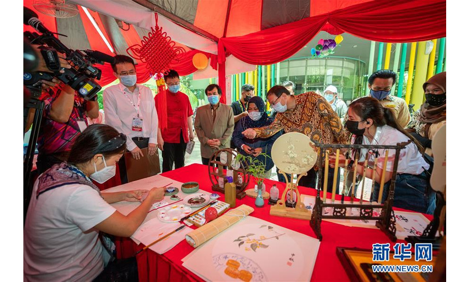 9月26日，在马来西亚吉隆坡附近的马来西亚国家动物园，来宾在“中马文化旅游月·相约大自然”活动上观看中国绘画技艺。 由吉隆坡中国文化中心主办的“中马文化旅游月·相约大自然”活动26日在马来西亚国家动物园拉开帷幕，吸引了当地众多市民参与。 新华社记者 朱炜 摄