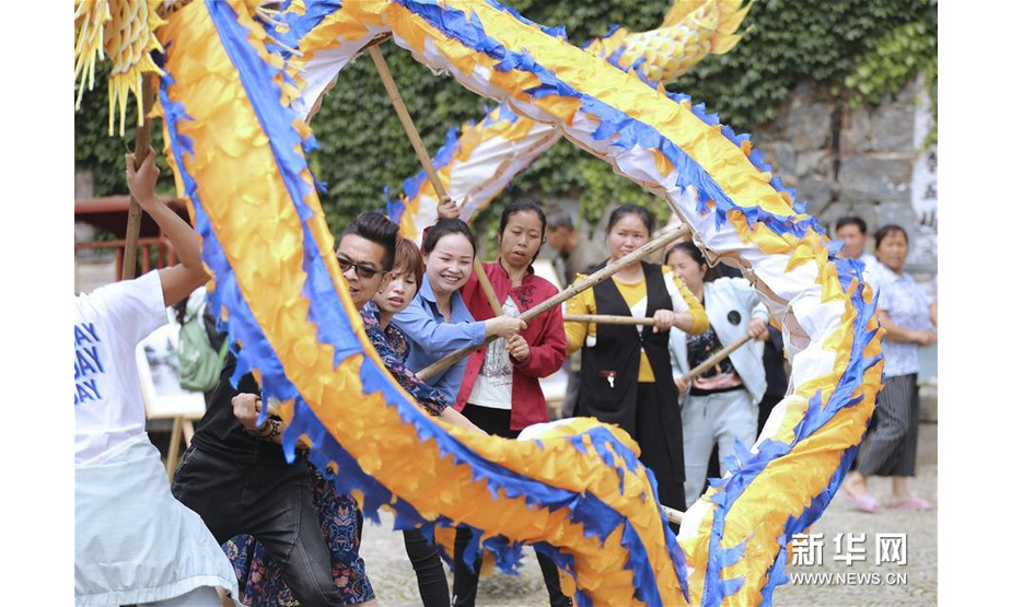 5月15日，人们在锦屏县隆里古城体验舞花脸龙。新华社发（杨晓海 摄）