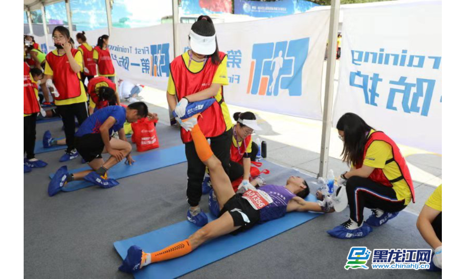 黑龙江网8月25日讯（记者 彭植）今日，2019哈尔滨国际马拉松正式开跑。图为防护站工作人员为赛员做拉伸训练，防止运动损伤。 彭植 摄