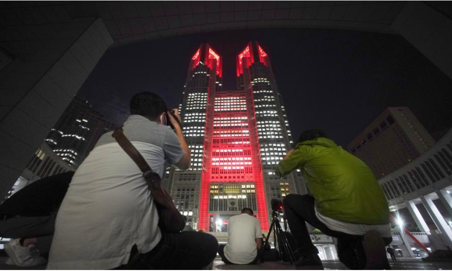2日晚11时后，东京都政府大楼和东京湾地标性建筑“彩虹桥”亮起象征“警戒”的红色以唤起民众的注意。图为东京地标之一，东京都政府大楼亮起红灯。
