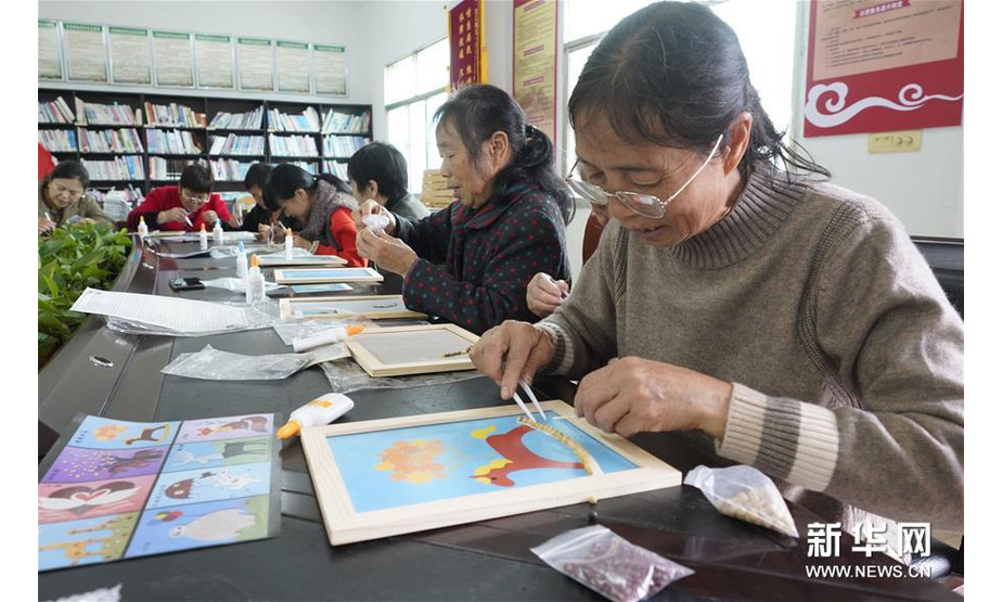 10月26日，在重庆市北碚区澄江镇五一村，村民在体验五谷粮食画制作技艺。 新华社发（秦廷富 摄）
