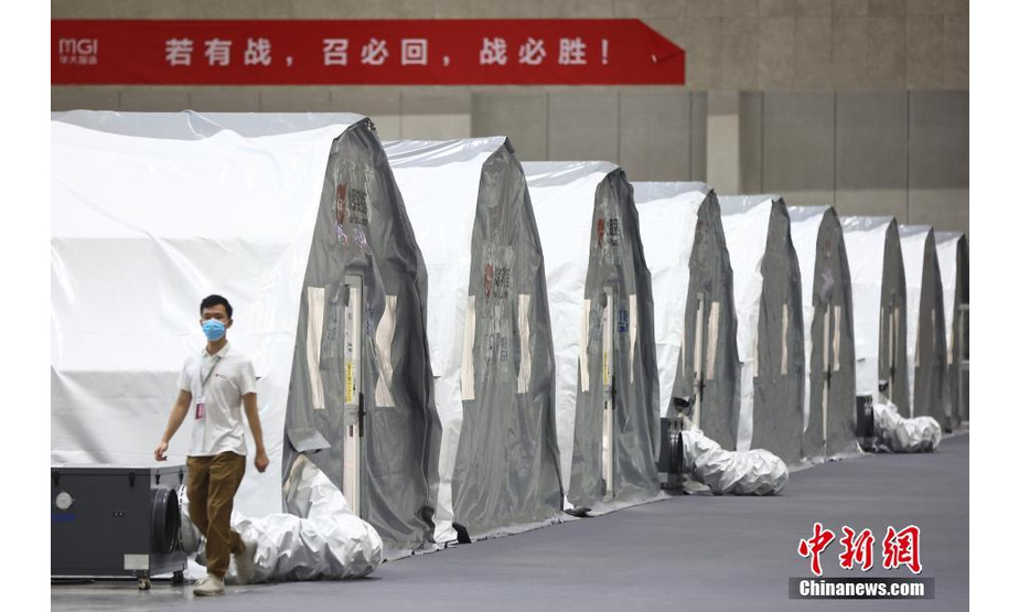 7月26日，南京“火眼”实验室正在南京国际博览中心加紧搭建，工作人员调试设备。实验室建造面积达8000平方米、配备12个硬气膜实验室和15个软气膜实验室，同时配备了全自动分杯处理系统、高通量自动化病毒核酸提取设备等，能够在快速提高检测效率的同时，降低检测人员感染的风险。该实验室全部建成后，若采用“10人混采”模式，单日核酸检测能力最高可达200万人份。