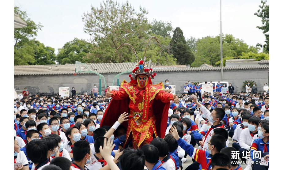 5月10日，民间艺人为学生们展示川剧变脸。新华社发（周良 摄）