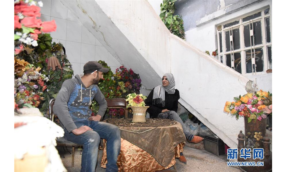 3月12日，在叙利亚大马士革东古塔地区，穆罕默德·谢哈德（左）和萨米拉·阿尤布夫妇坐在家中。 新华社发（胡马姆·谢赫·阿里 摄）