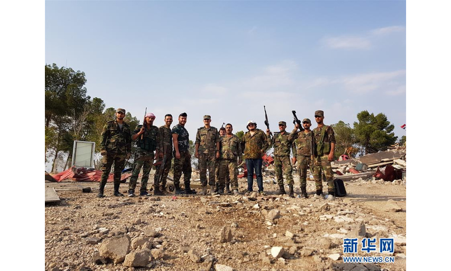 10月19日，在叙利亚哈塞克省西部的格斯尔亚勒达村，叙利亚政府军士兵在一个军事基地内合影。 叙利亚军方人士19日说，叙政府军当天进驻叙东北部哈塞克省一个由美国领导的国际联盟部队撤出后留下的军事基地，其内部设施已被严重破坏。 新华社发
