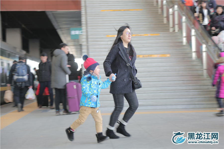 乘客带着孩子奔向火车。 石启立 摄