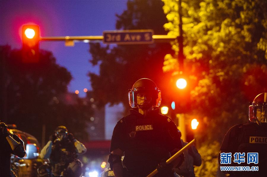 5月30日晚，在美国明尼苏达州明尼阿波利斯市，防暴警察在街头警戒。新华社发（安格斯·亚历山大摄）