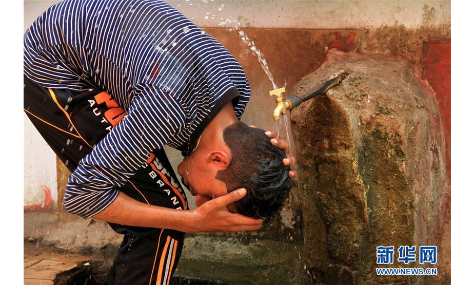 　5月22日，在巴基斯坦卡拉奇，一名男孩用水给自己降温。近日，巴基斯坦南部城市卡拉奇连遇高温天气，最高气温达44摄氏度，已造成至少65人死亡。新华社发