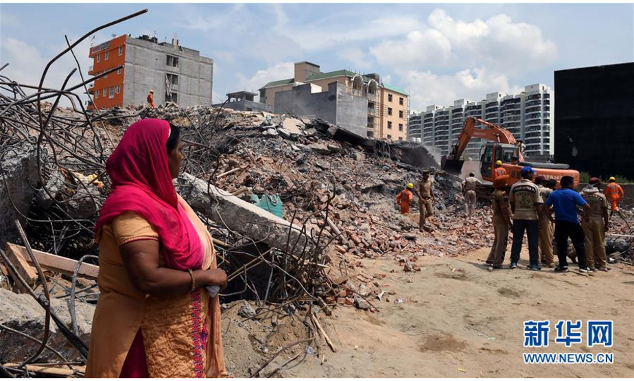 7月19日，在印度北方邦沙阿贝里村的楼房倒塌事故现场，一名女子注视救援行动。 印度北方邦沙阿贝里村17日晚发生一起两栋楼房倒塌事故，截至当地时间18日晚，死亡人数已升至9人。 新华社记者张迺杰摄