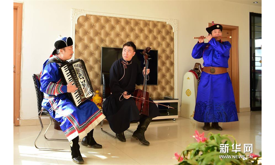 11月21日，乌兰牧骑队员在群众家中表演节目。新华社发（贝赫 摄）