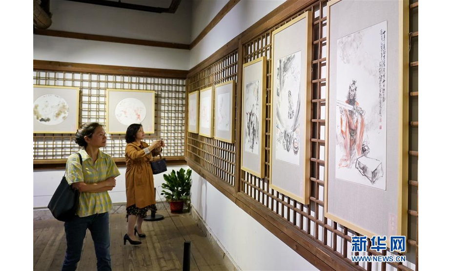 2019年5月22日，由福建省美术家协会主办的“一家一品——中国画名家瓷画邀请展”在福建省海峡民间艺术馆亮相，展出了近八十件将水墨画嫁接在瓷板上的创新瓷画。 图为5月22日，美术爱好者在参观瓷画。新华社记者林善传摄