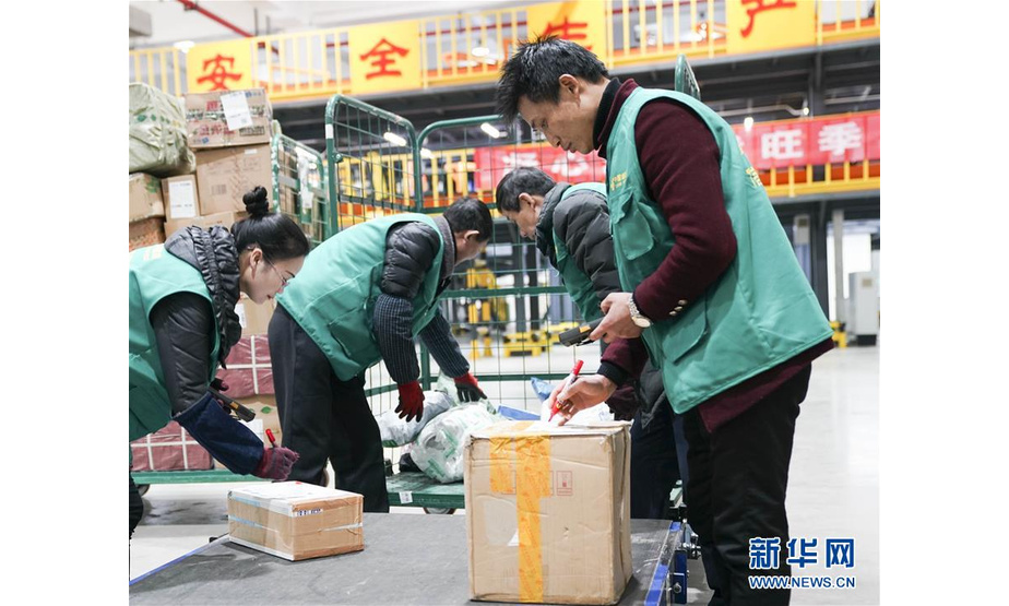2月6日，在重庆市邮区中心局第三邮件处理中心，分拣员在人工邮件分拣线的邮件上线口仔细核对邮件信息并及时进行邮区标记登记。