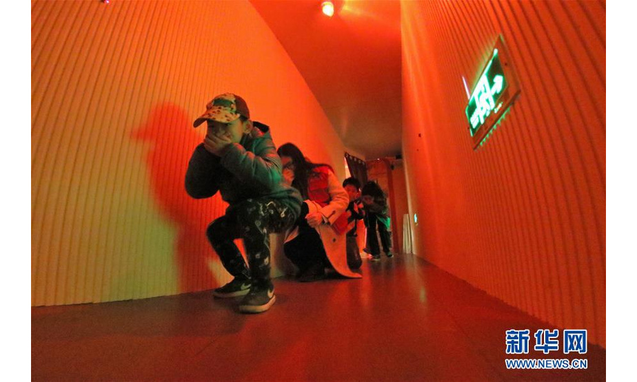 3月23日，小朋友在山东省烟台市青少年宫消防安全教育馆体验烟雾场景模拟逃生。  新华社发（唐克 摄）