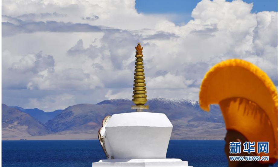 这是7月21日在玛旁雍错湖边拍摄的佛塔和僧人。 玛旁雍错湖位于西藏阿里地区的普兰县境内，海拔4588米，面积412平方公里，四周雪山为湖泊常年补水，是著名的旅游胜地。 新华社记者 觉果 摄