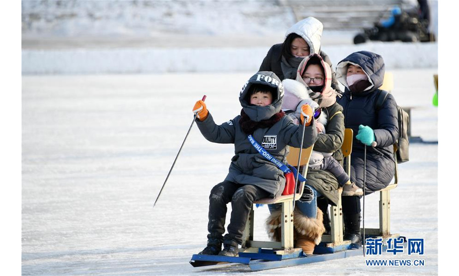 2月7日，在松花江上的“江上大众冰雪嘉年华”游乐区，游客在冰面上游玩。