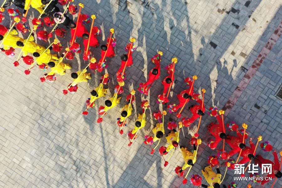 12月27日，民间艺人在河南省平顶山市宝丰县张八桥镇姚店铺村表演非遗经担舞（无人机照片）。新华社发（何五昌 摄）