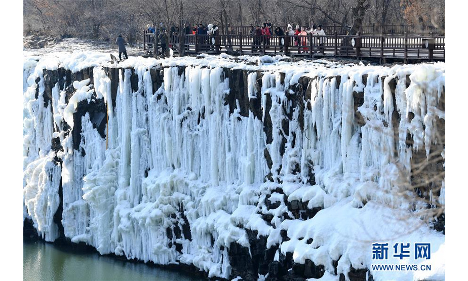 2月25日，游客在观赏冰瀑景观。 去冬今春以来，黑龙江省镜泊湖的吊水楼冰瀑景色壮观，吸引许多游人前来观赏。 新华社记者 王建威 摄
