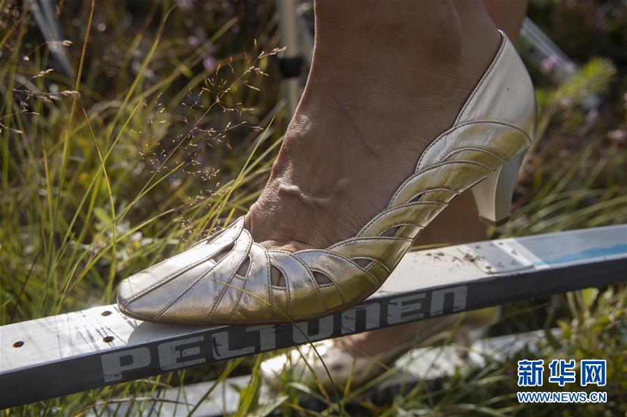 8月10日，在芬兰北部的普达斯耶尔维，一名女子穿着高跟鞋脚踩滑雪板，参加“花裙高跟鞋 滑越沼泽地”趣味赛事。 在芬兰北部的普达斯耶尔维举行的“花裙高跟鞋 滑越沼泽地”趣味赛事已有14年的历史，参赛者要穿着花裙和高跟鞋，脚踩滑雪板滑行穿过30米的沼泽地带。相对于冬天在雪地上滑雪，夏日里在沼泽地滑行需要耗费更多的体力并掌握更多技巧，参与者也从中享受到了别样的乐趣。 新华社发（马蒂·马蒂凯宁摄）