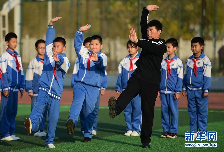 11月19日，沧州青县实验小学的学生在体育老师的指导下练习盘古王拳。 近年来，“武术之乡”河北省沧州市教育、体育部门对体育教师进行强化培训和技术指导，并根据青少年身心特点，编制融合当地特色拳种特点的系列武术教材，持续推进传统武术进校园活动。 新华社记者 王民 摄