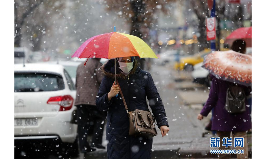 1月13日，在土耳其安卡拉，行人在雪中行走。新华社发（穆斯塔法·卡亚摄）