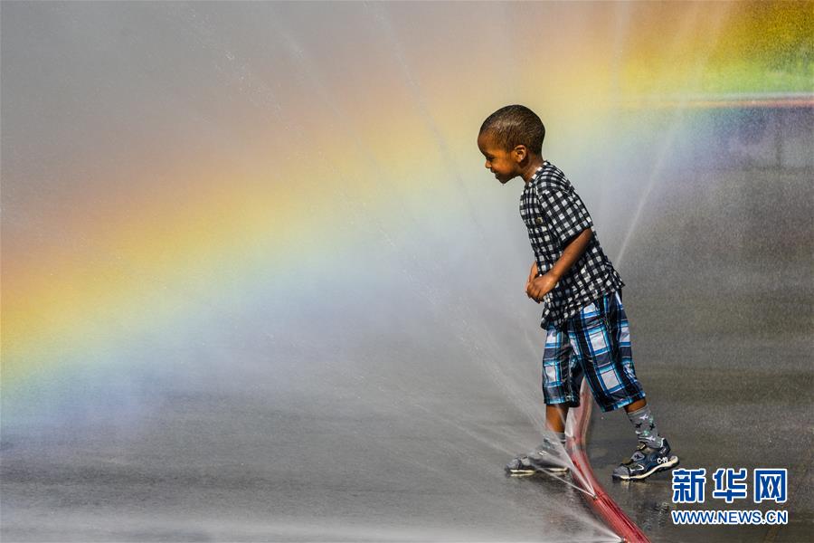 6月26日，一名儿童在奥地利维也纳施瓦岑贝格广场戏水消暑。 7月12日是今年“三伏”中“初伏”的第一天，这意味着高温高湿的“桑拿天”将逐渐成为天气“主角”，我国大部分地区开启“蒸煮模式”或“烧烤模式”。 而近日北半球多地也处在高温酷暑中。 新华社记者 郭晨 摄