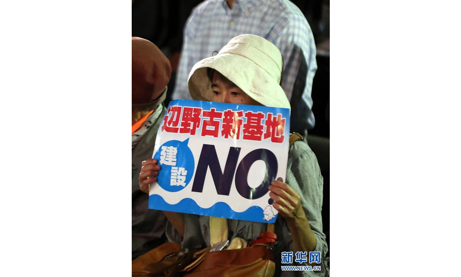 9月19日，在日本东京，一名民众手持标语参加集会。当日，近5000人在东京日比谷公园内参加反对新安保法集会。新华社记者 杜潇逸 摄