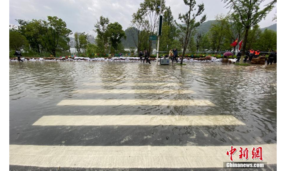 7月8日，浙江杭州建德新安江边的道路出现积水。当日，受浙江建德新安江水库9孔泄洪影响，当地出现部分民房、学校、道路等受淹现象。 中新社记者 王刚 摄
