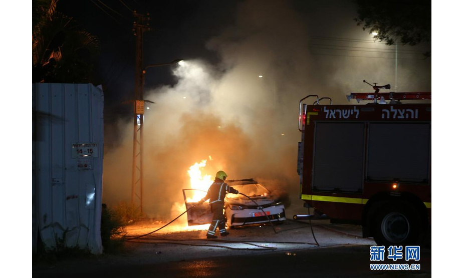 5月12日，在以色列中部城市卢德，消防员准备为一辆燃烧的警车灭火。

　　以色列总理办公室12日凌晨发表声明宣布，以中部阿拉伯人与犹太人混居城市卢德进入紧急状态。

　　新华社发（穆阿迈尔·阿瓦德摄）